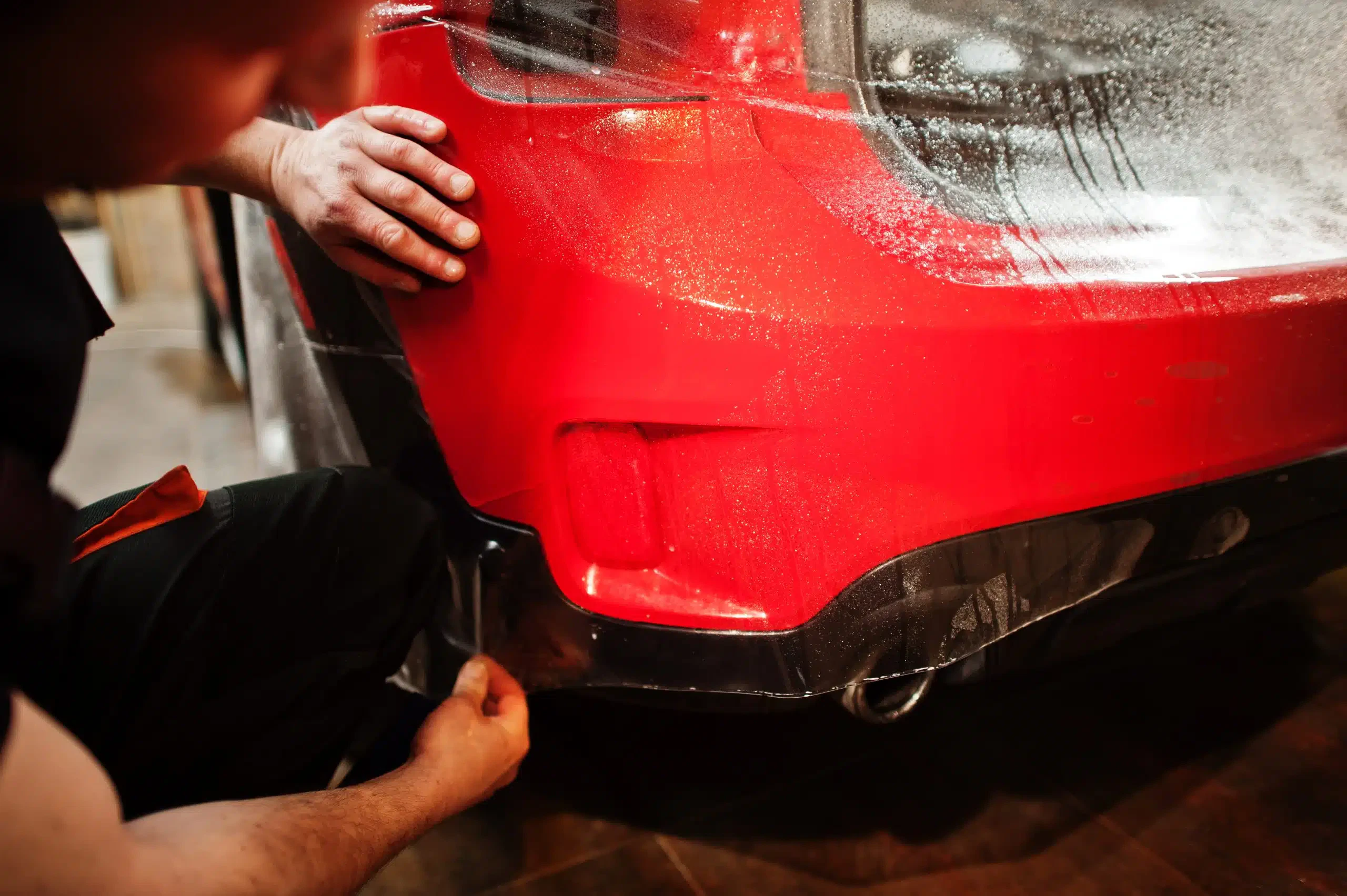 Applying protective film on red car