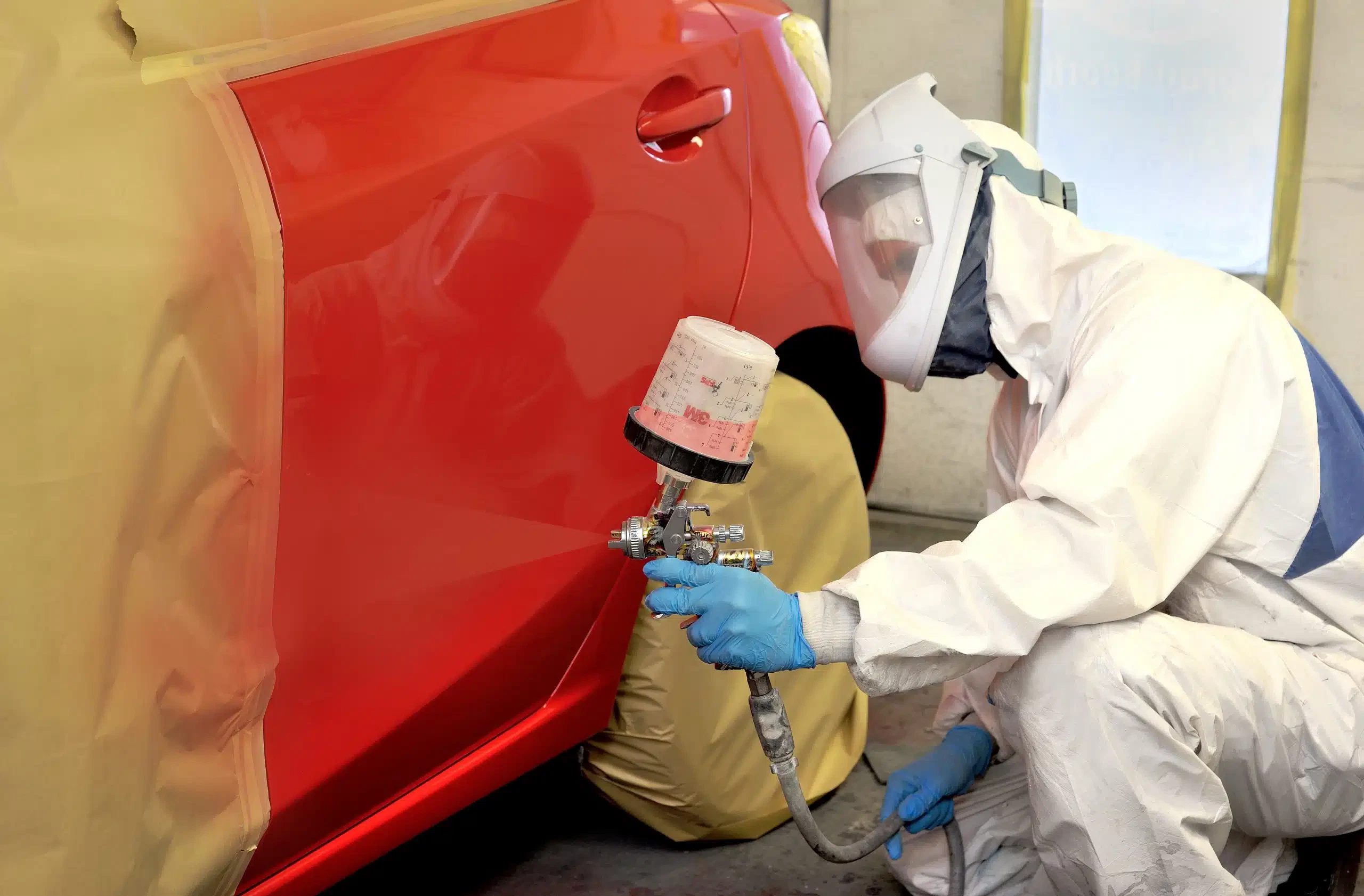 Technician painting a car