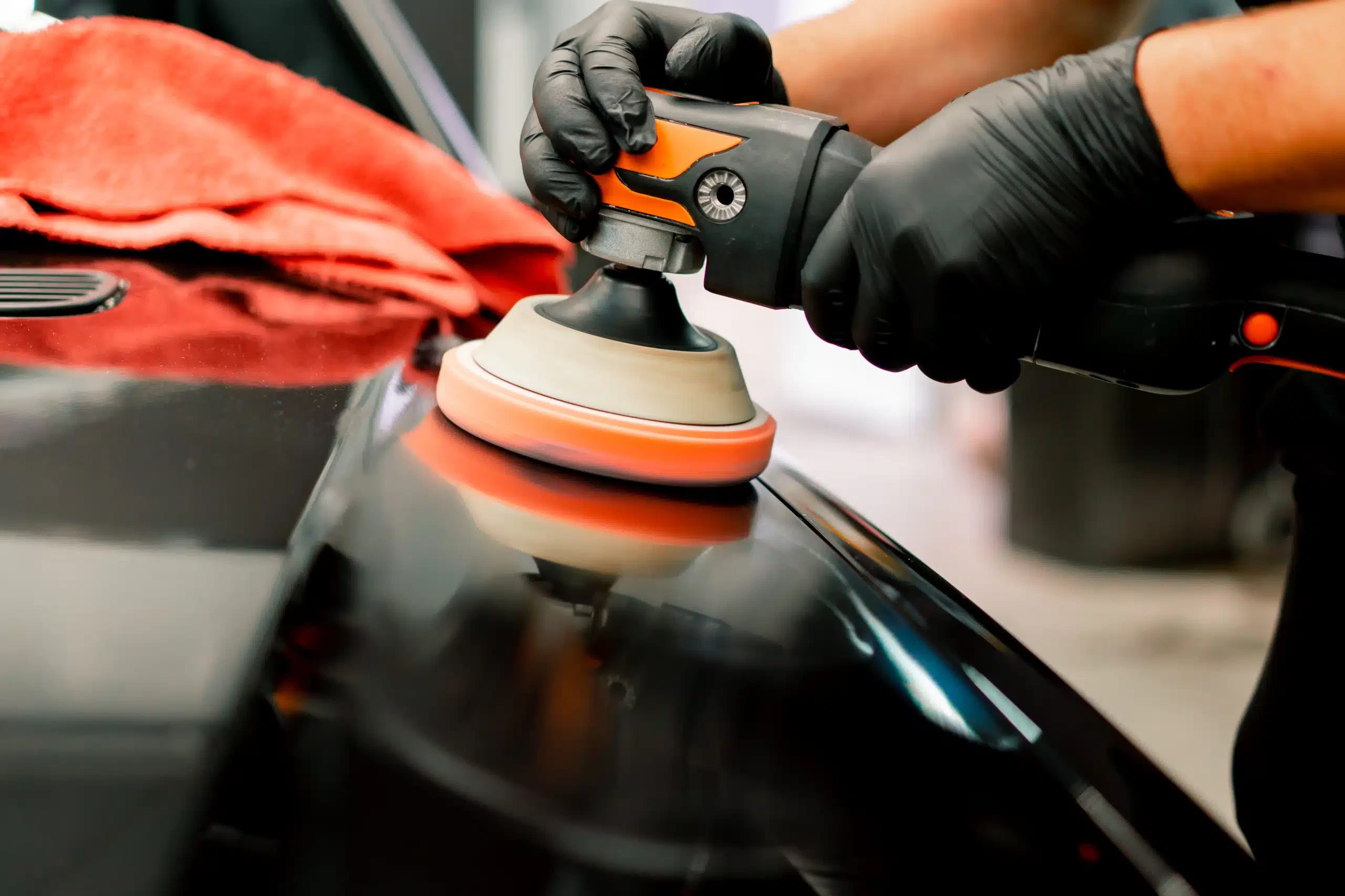 Worker polishing a car's surface.